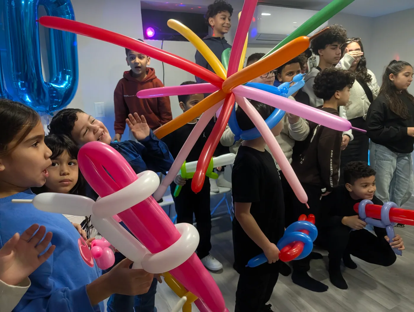 Children holding a large multicolored balloon creation