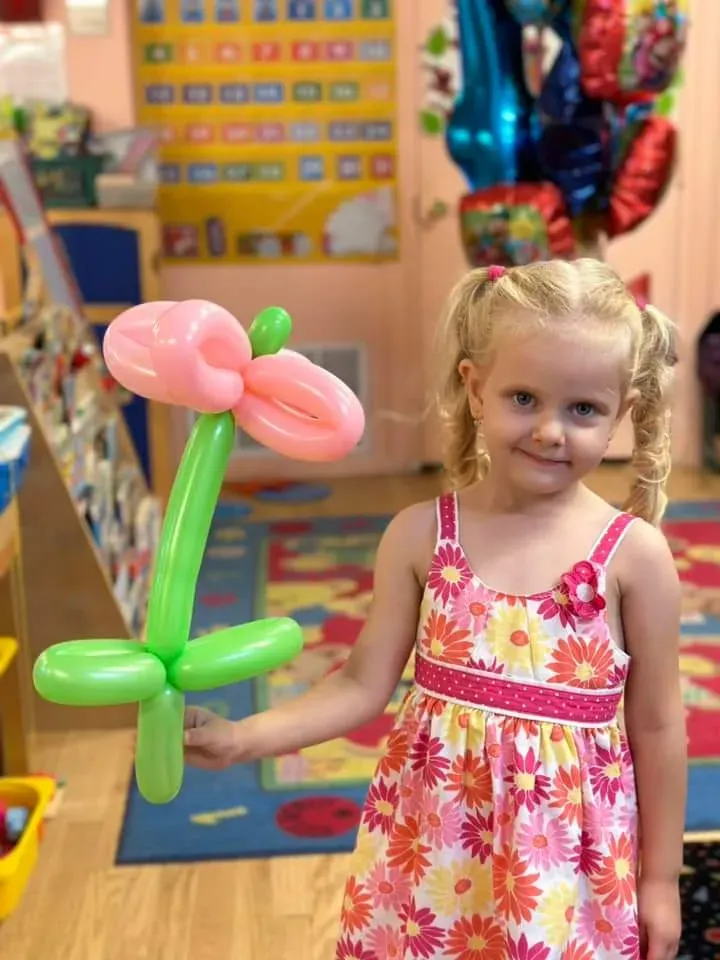 A child holding a tall balloon flower