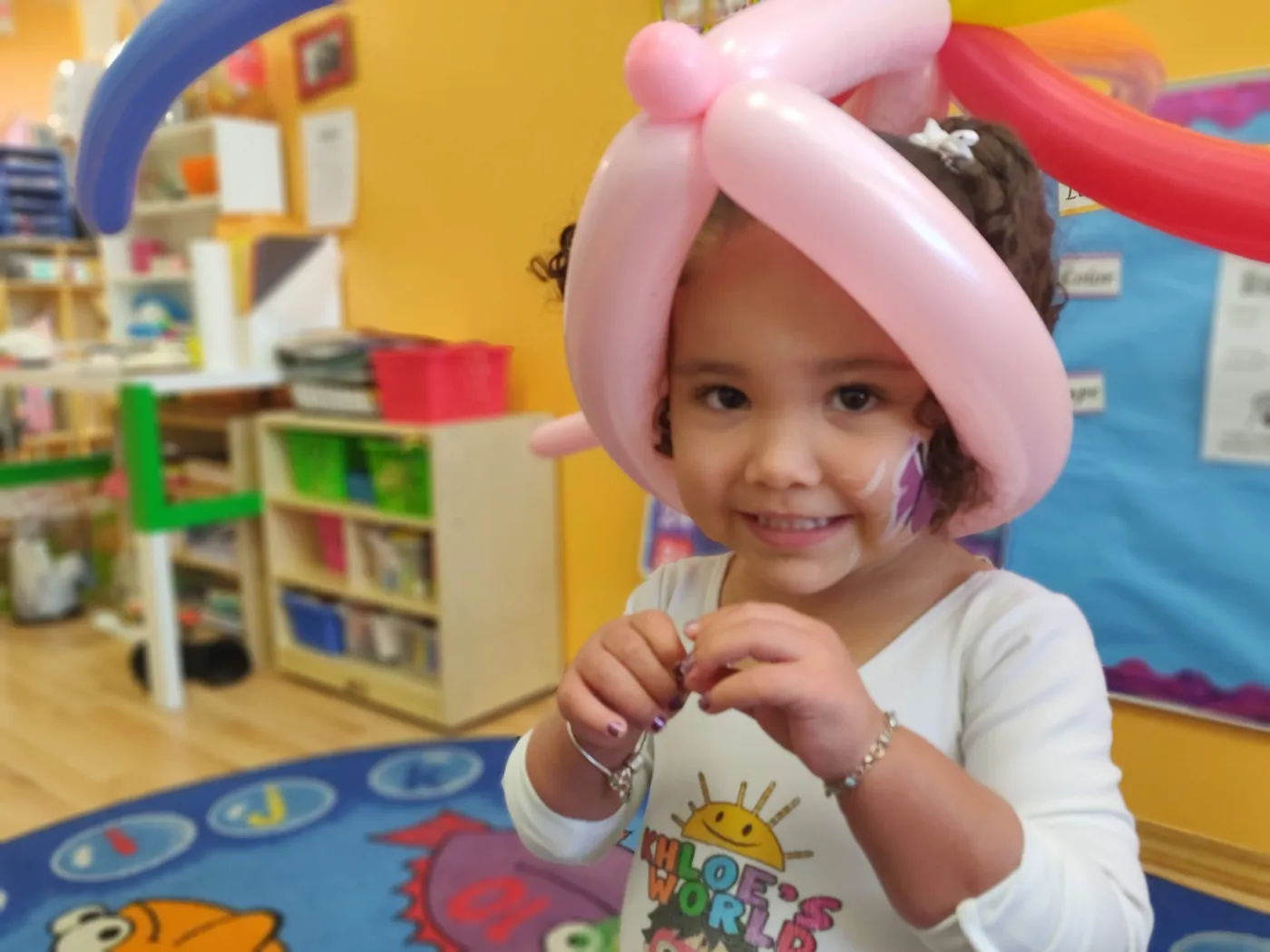 A child wearing a pink balloon hat