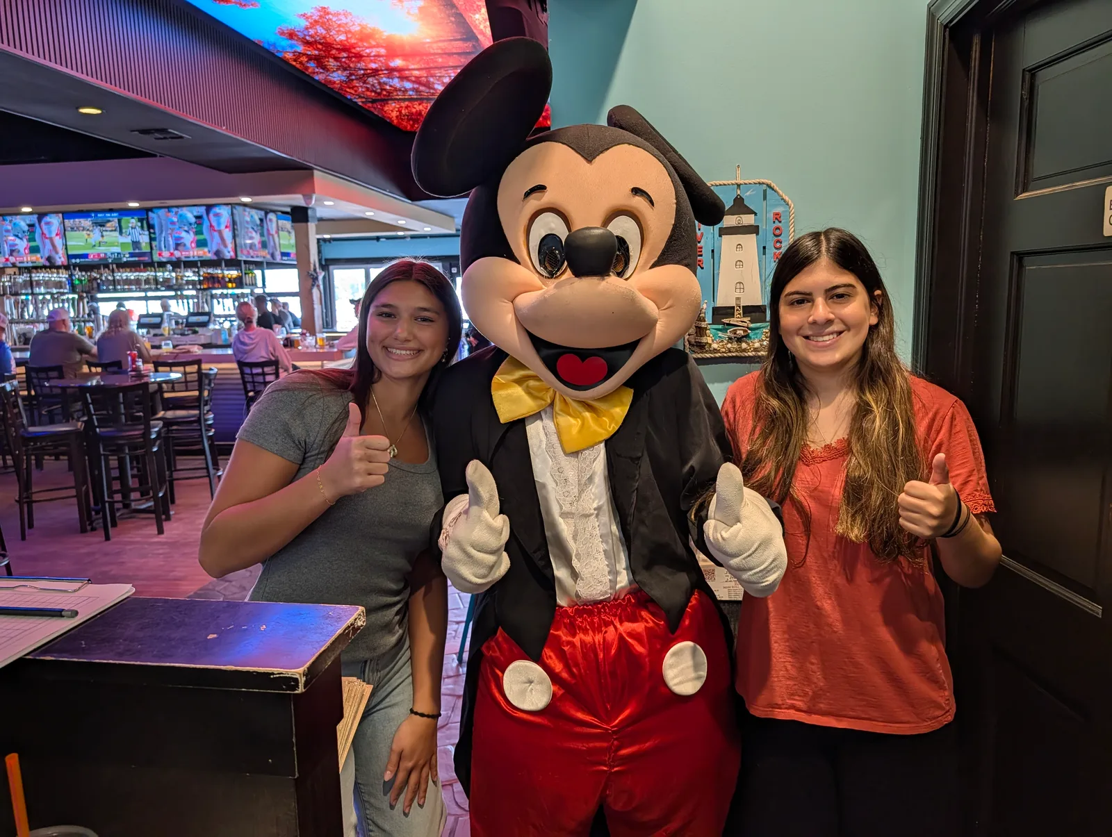 Guests posing with a mouse mascot at an indoor party