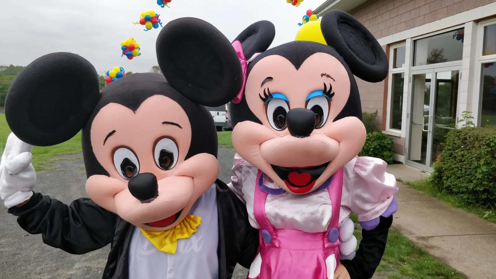 Two mouse mascots posing together outdoors