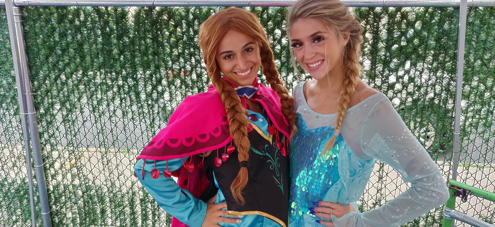 Two princess performers in blue and pink costumes posing together
