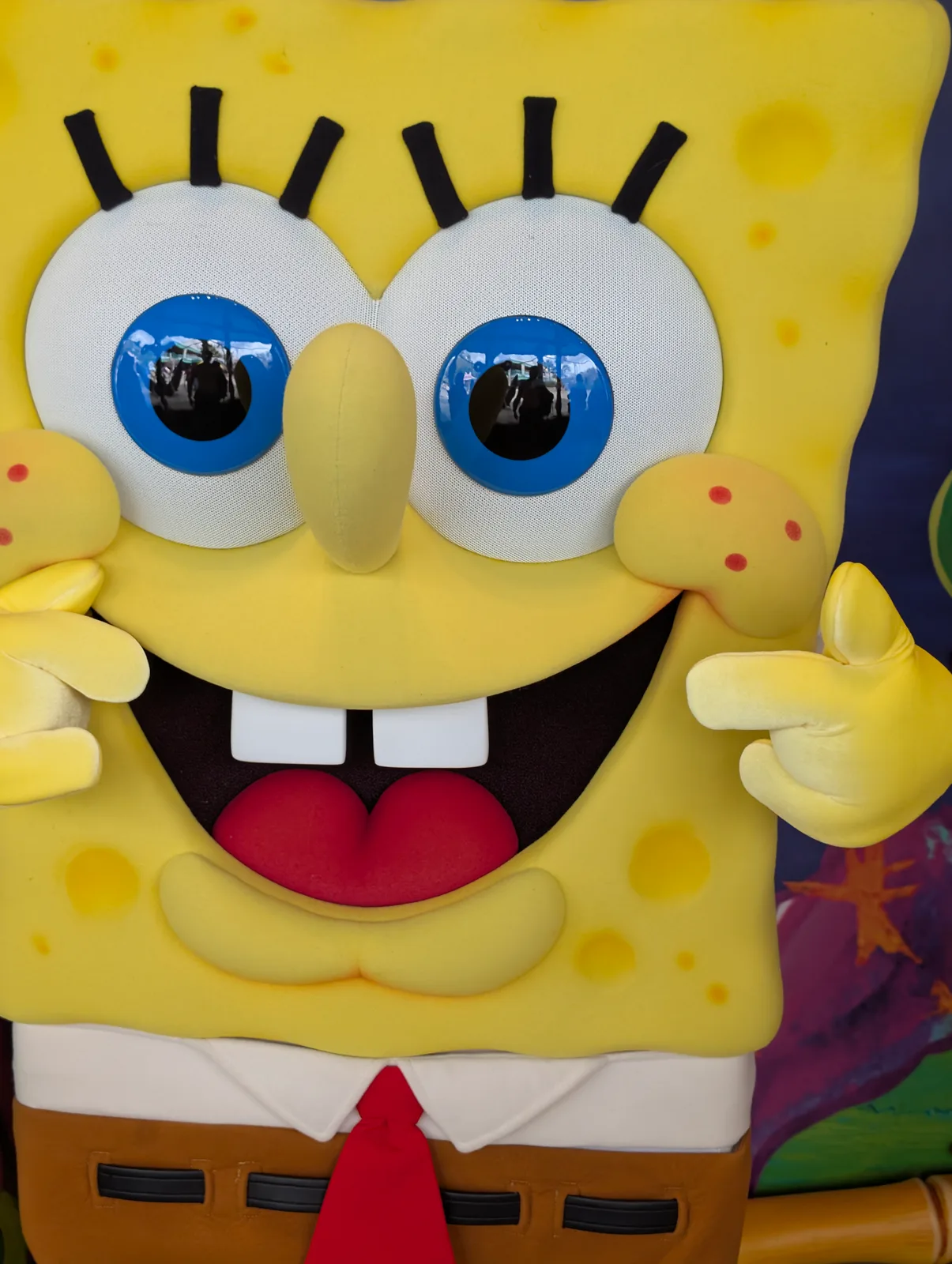 A yellow sponge mascot posing indoors