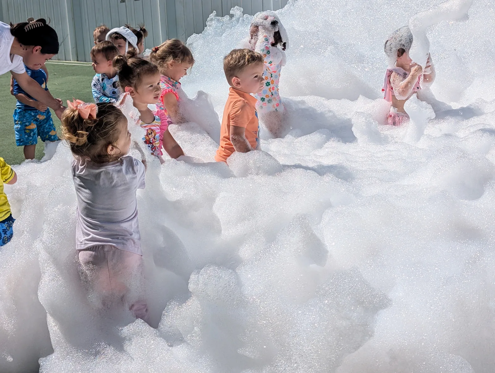 A group of children playing together in white foam