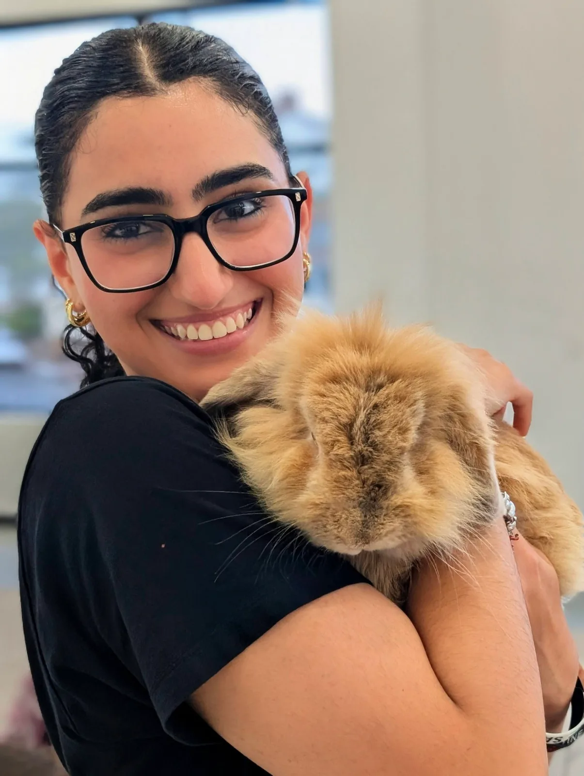 A guest holding a fluffy brown rabbit