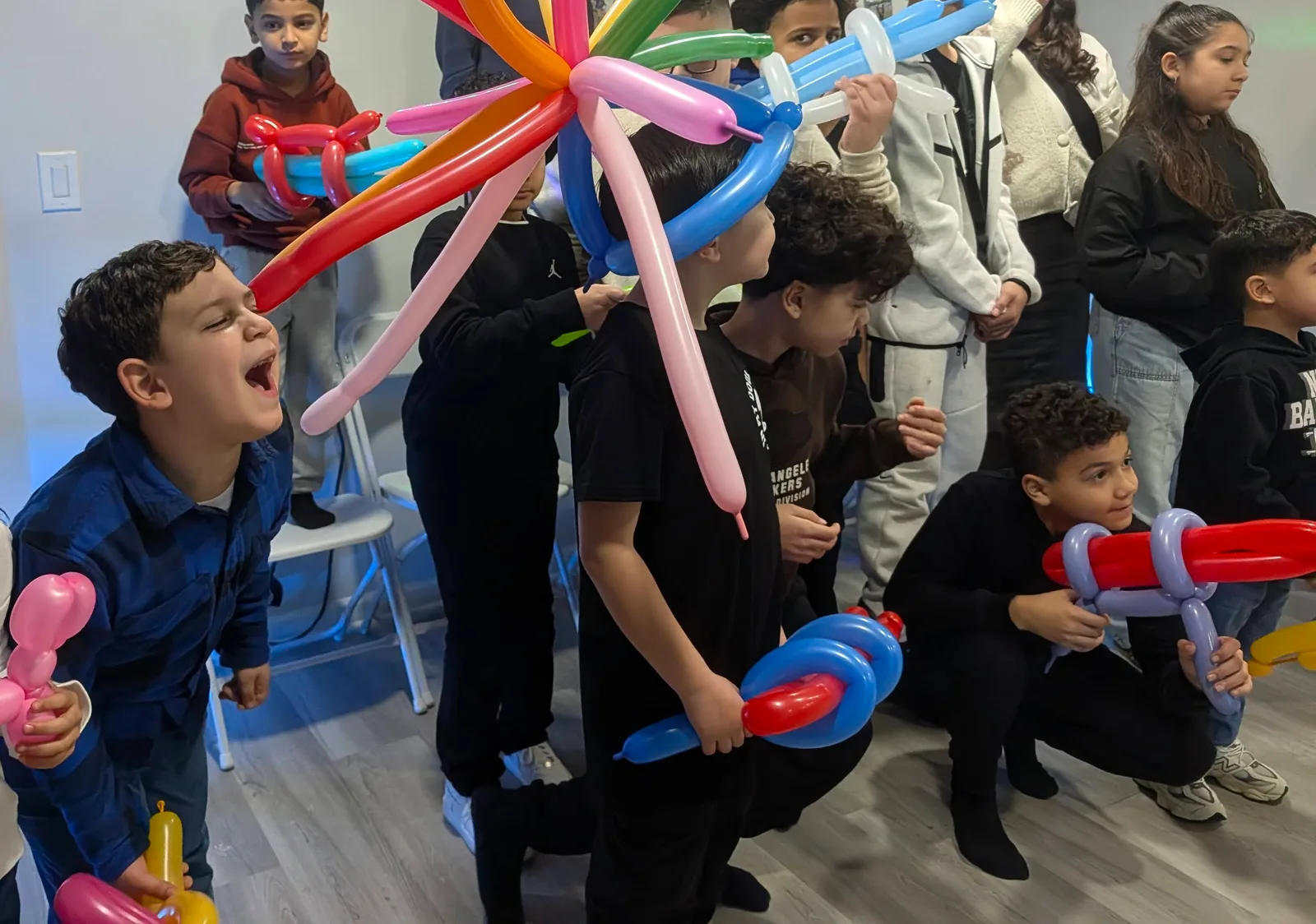 Children holding long colorful balloon sculptures