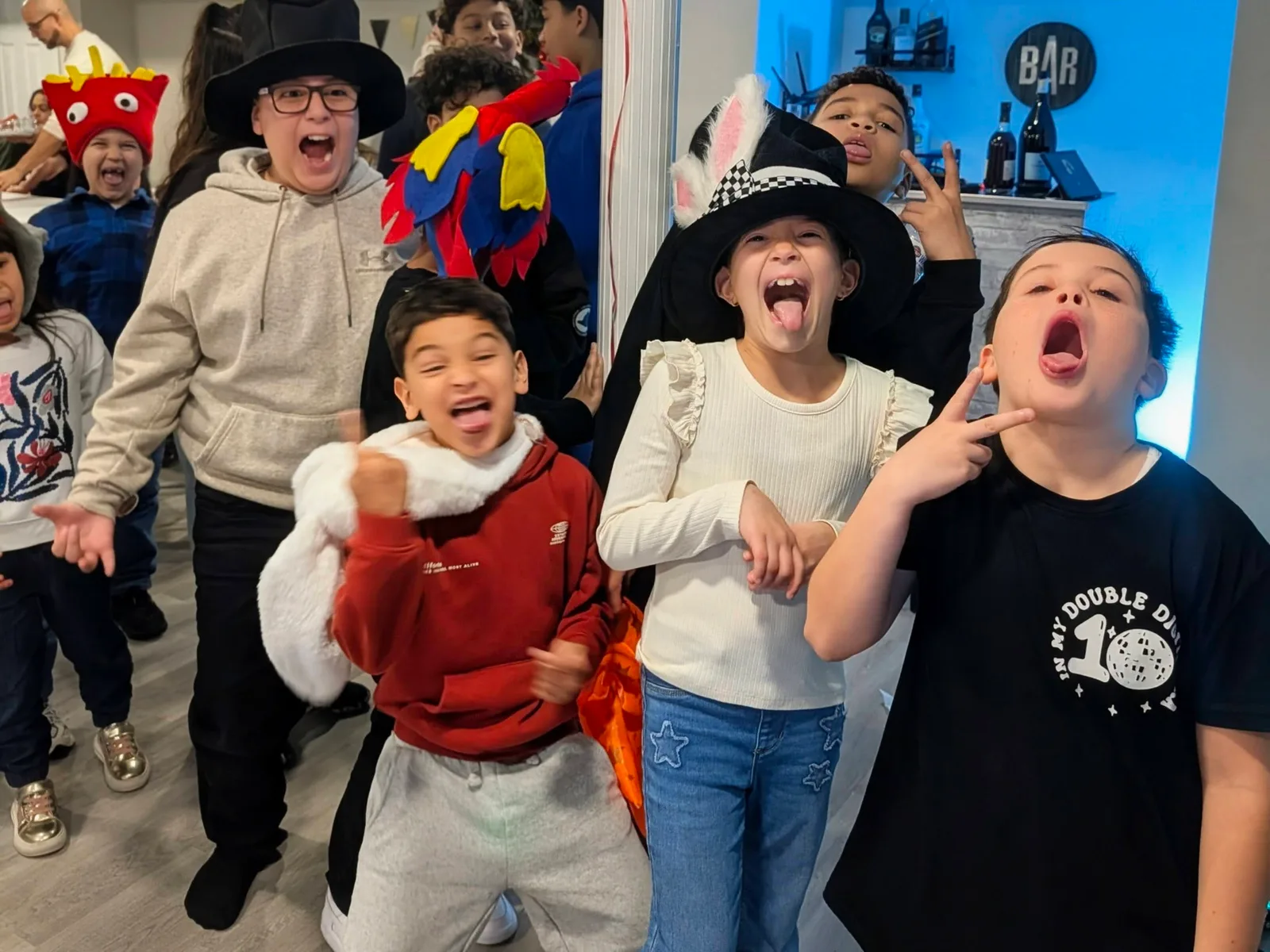 Children laughing together while wearing costume hats