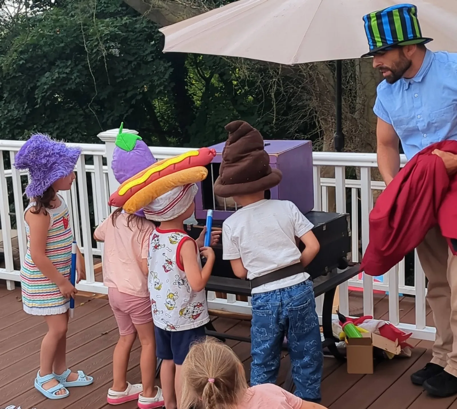 Children in colorful costume hats taking part in a magic show