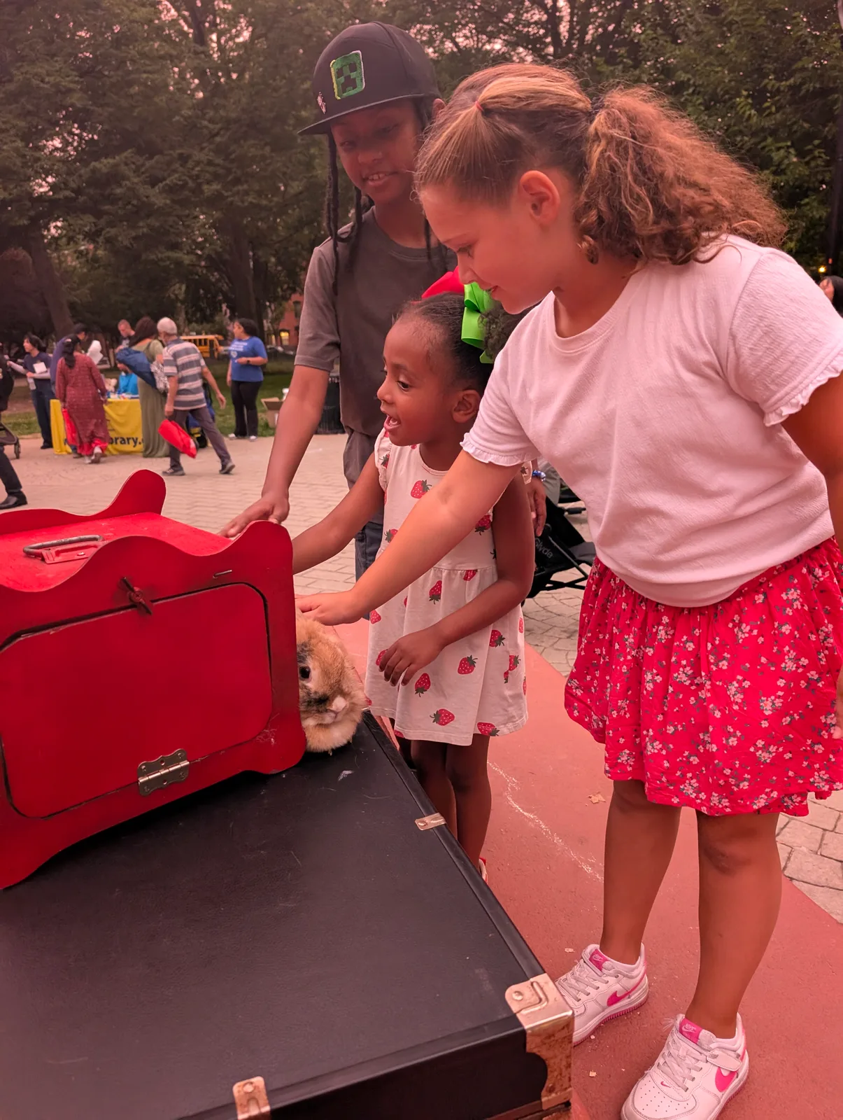 Two children helping at a red magic table