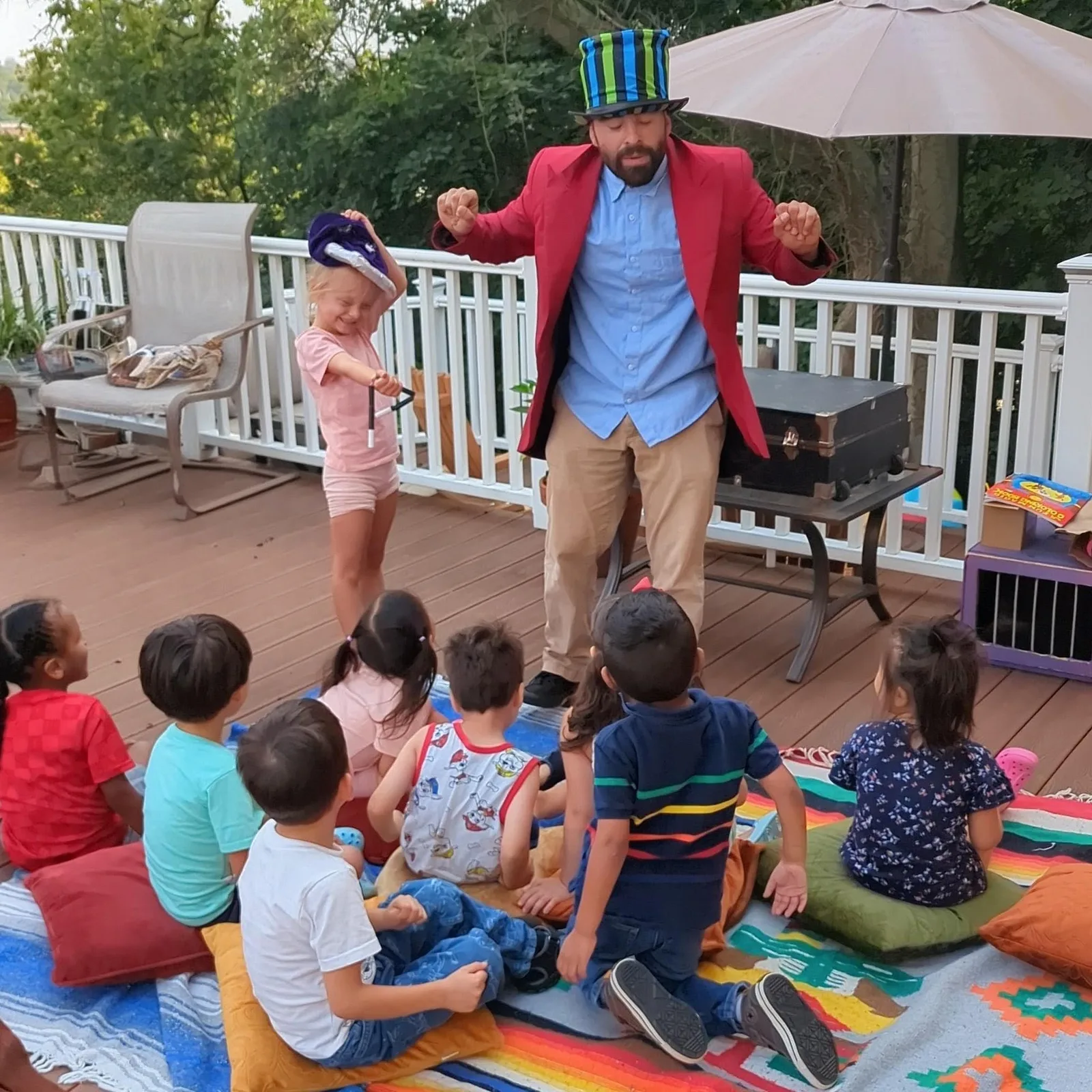 A young volunteer joining a magician in front of a seated audience