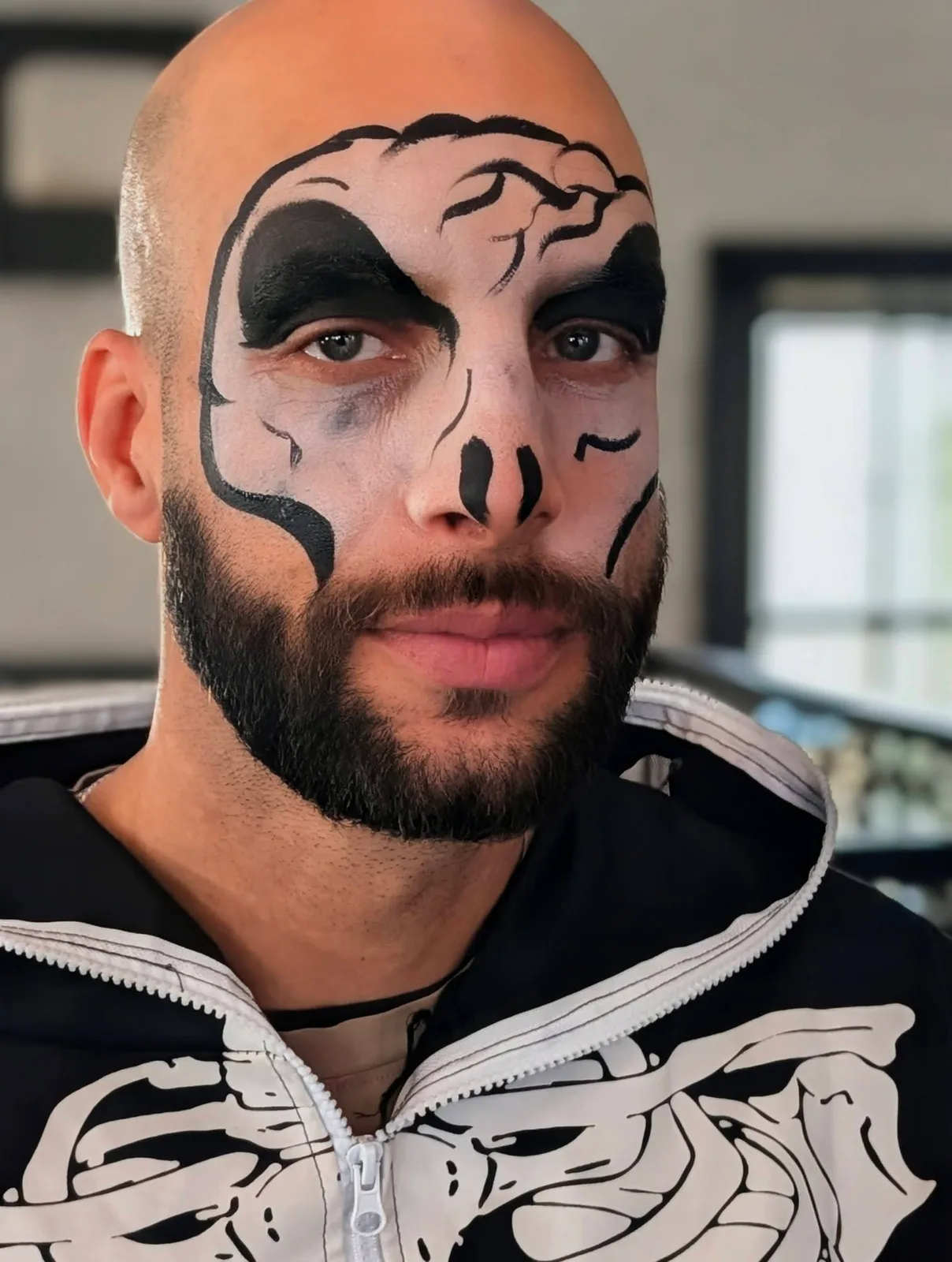 A guest wearing skull face paint and a skeleton shirt
