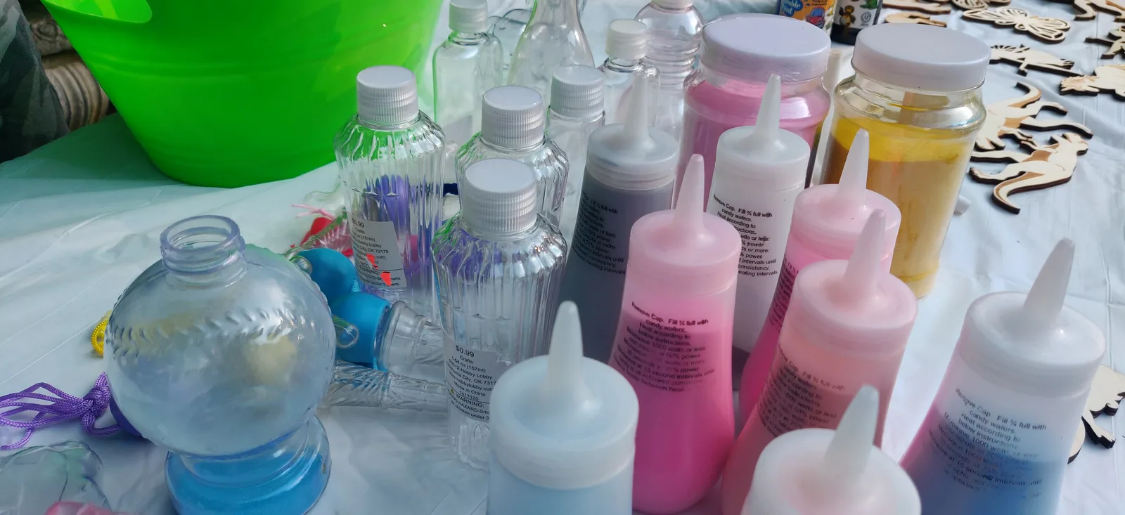 Bottles of colored sand and clear shaped containers arranged on a table
