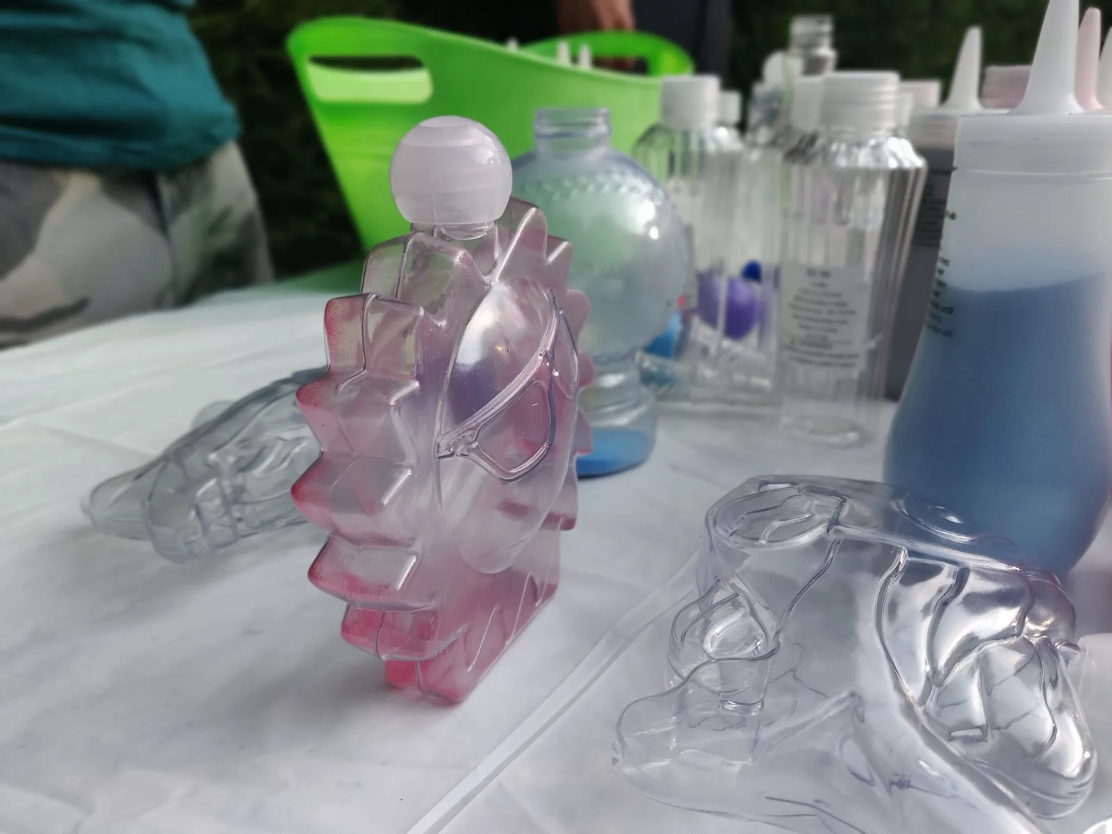 Clear star and dolphin shaped sand-art containers beside colored sand bottles