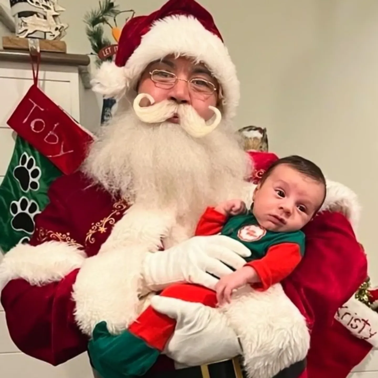 Santa holding a baby for a holiday photo