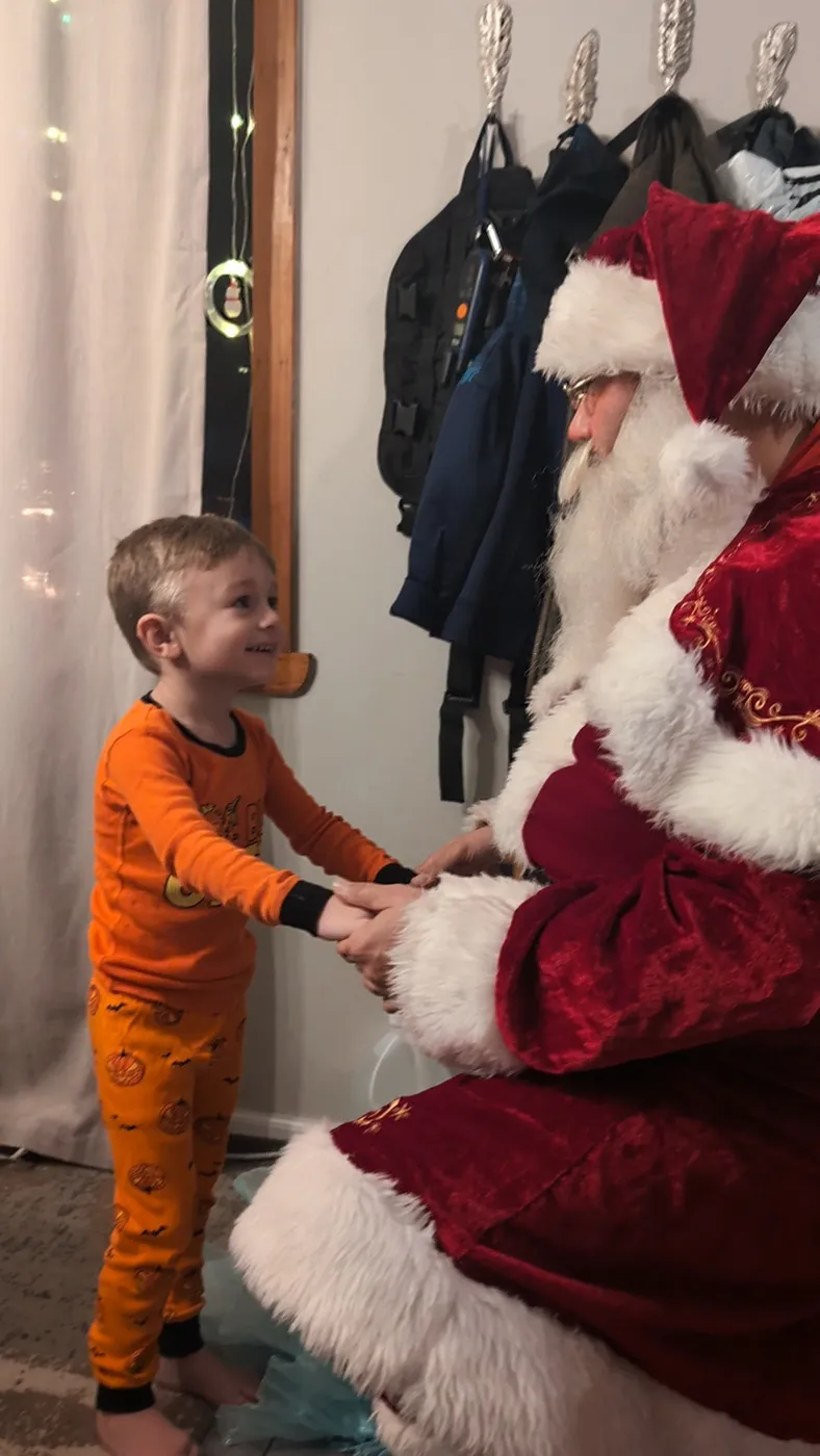 A child greeting Santa indoors