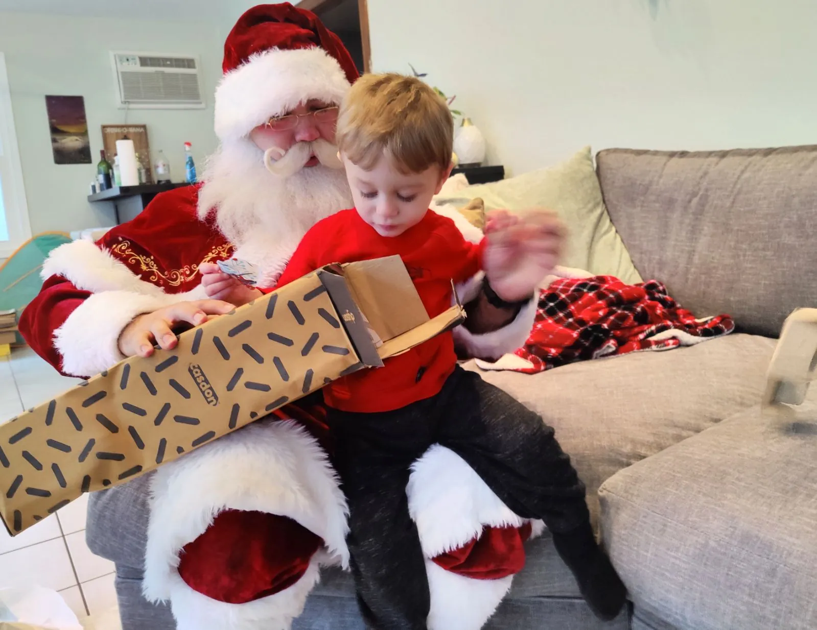 Santa and a child looking at a wrapped gift