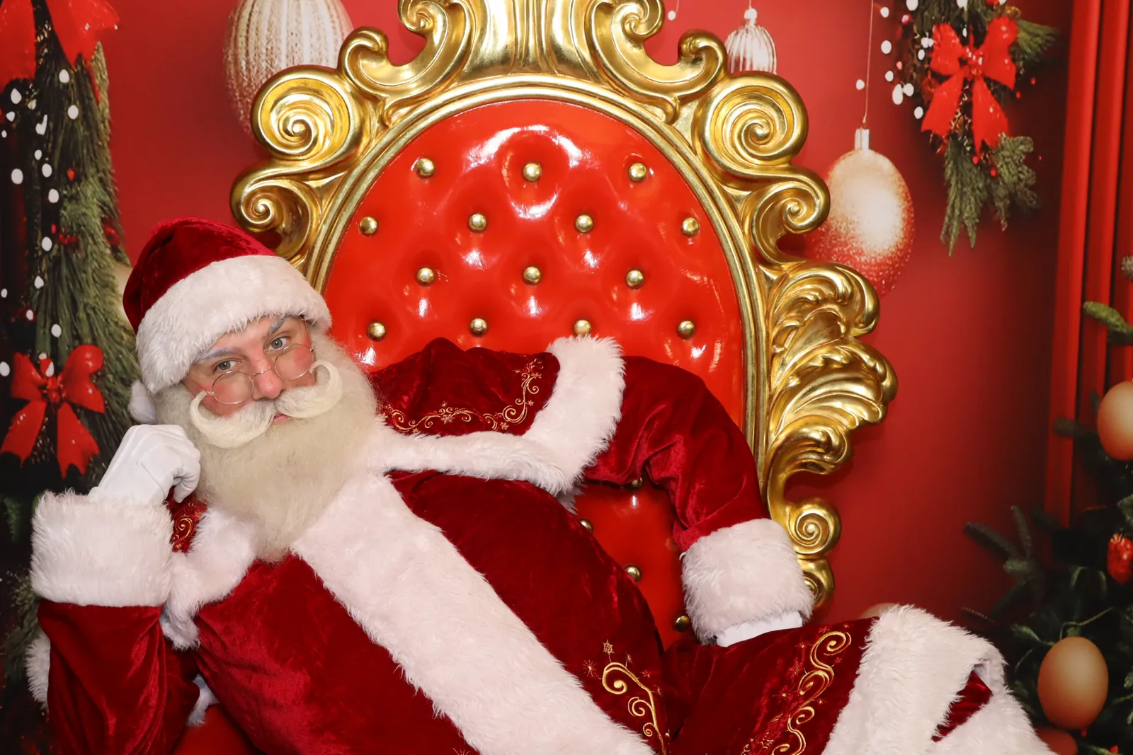 Santa seated in a decorated holiday chair