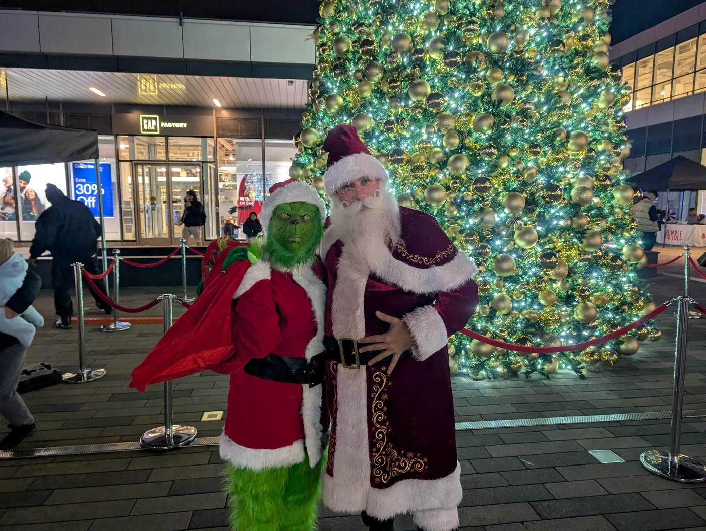Santa beside an outdoor Christmas tree
