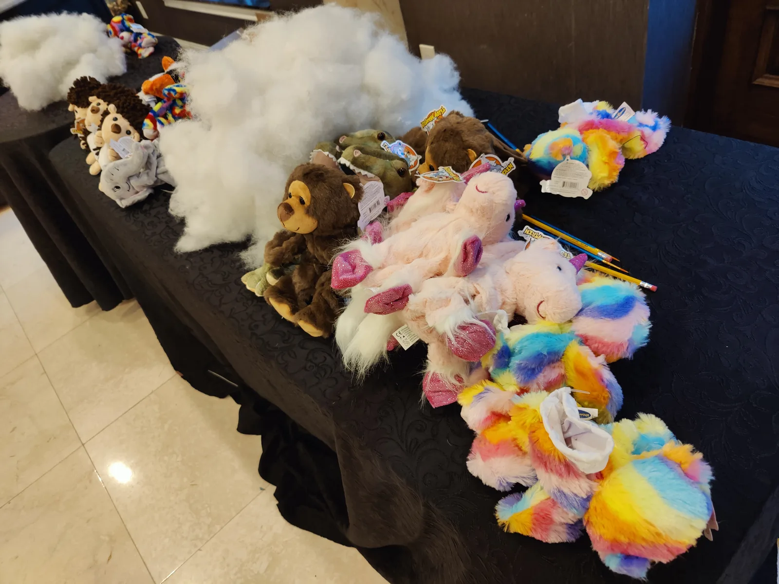 Unstuffed plush animals and a pile of white stuffing on a table