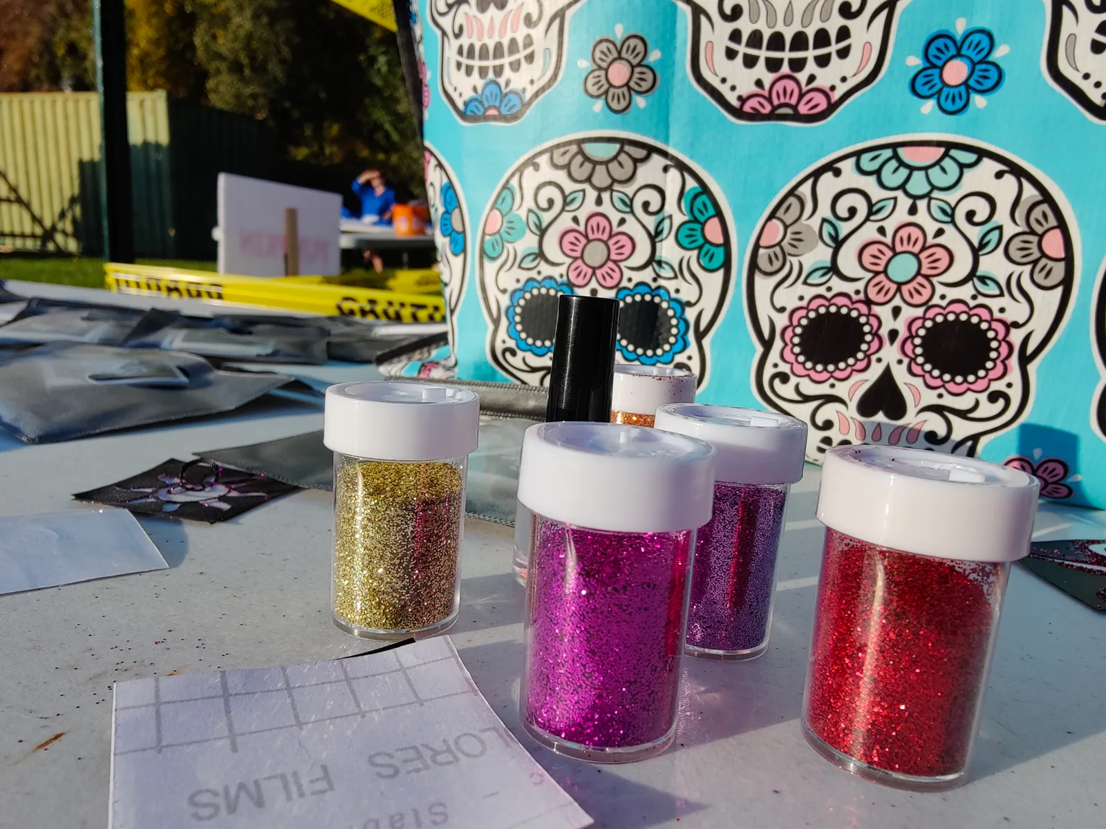 Pink, gold and red glitter pots beside a stencil display