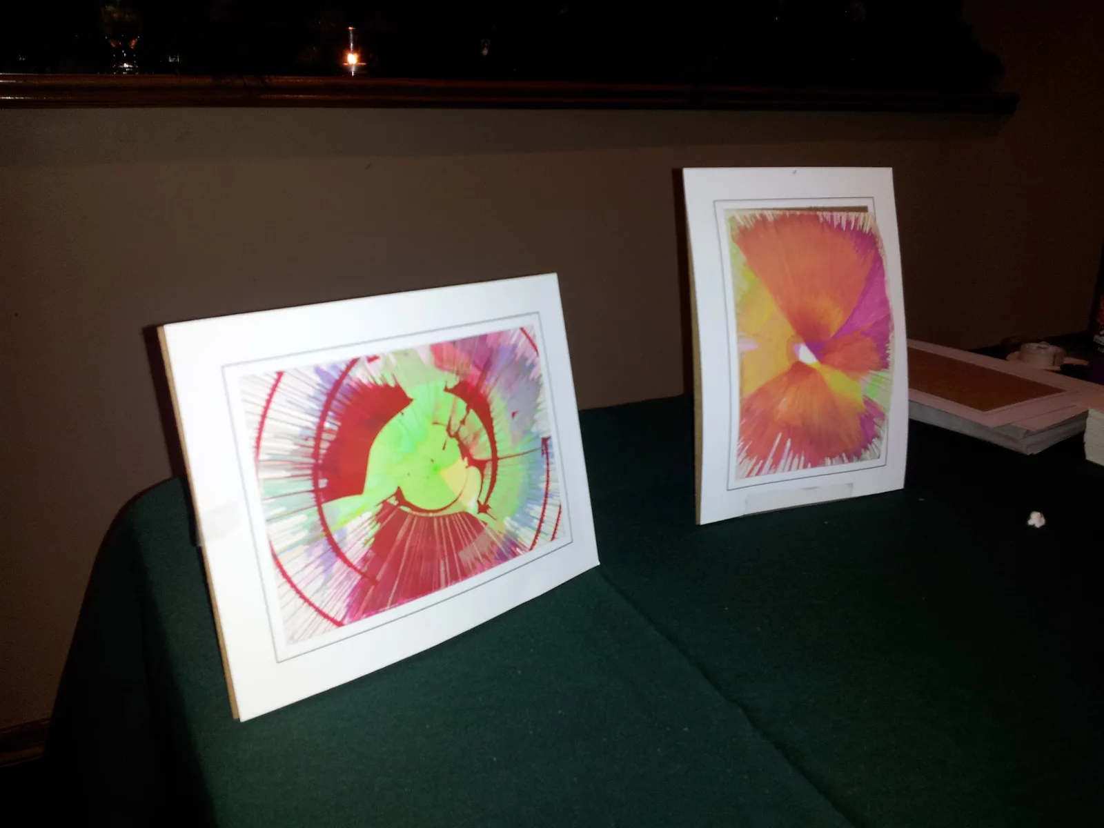 Two framed spin-art pictures with bright circular paint patterns